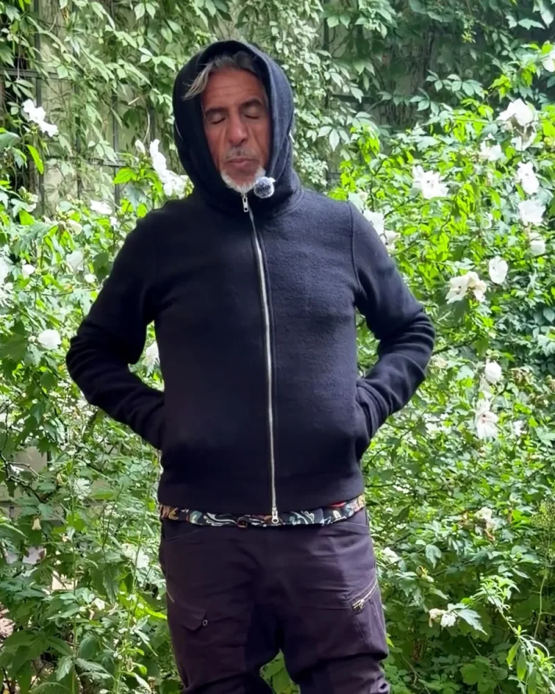Hamid trägt die Kapuze der Jacke Nilo, nur das Gesicht ist frei