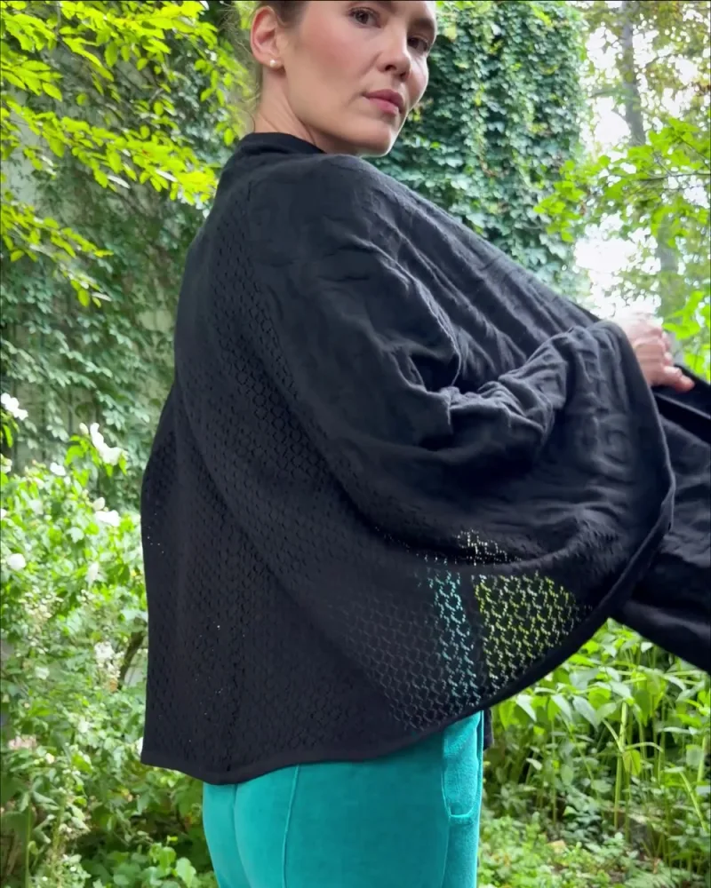 Elisabeth dreht sich im Poncho Jacqueline, an der Kante ein gestricktes Gittermuster