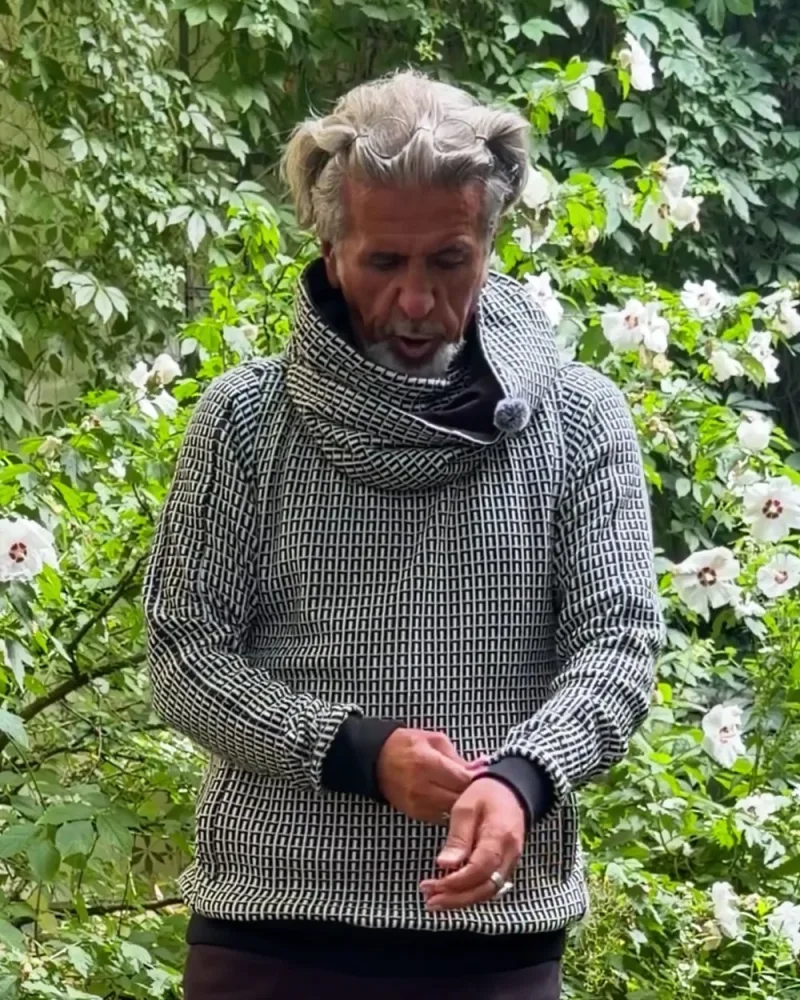 Hamid zieht die Stulpe des Pullovers Nils über die Hand