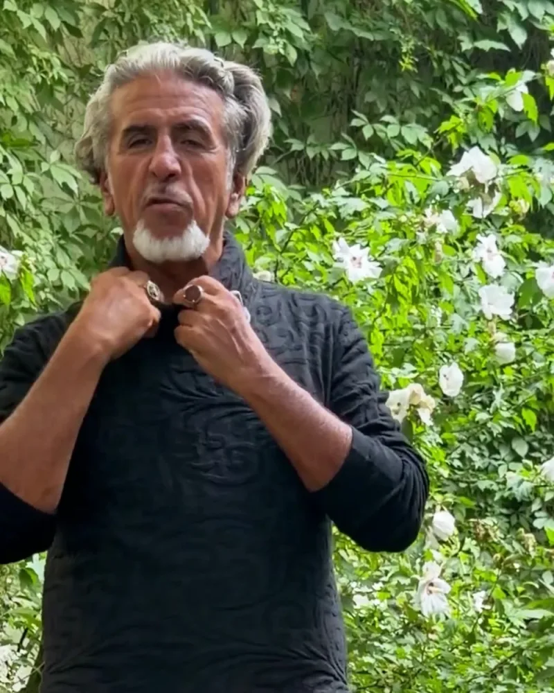 Hamid fasst an den lockeren Rollkragen des schwarzen Pullovers Younes