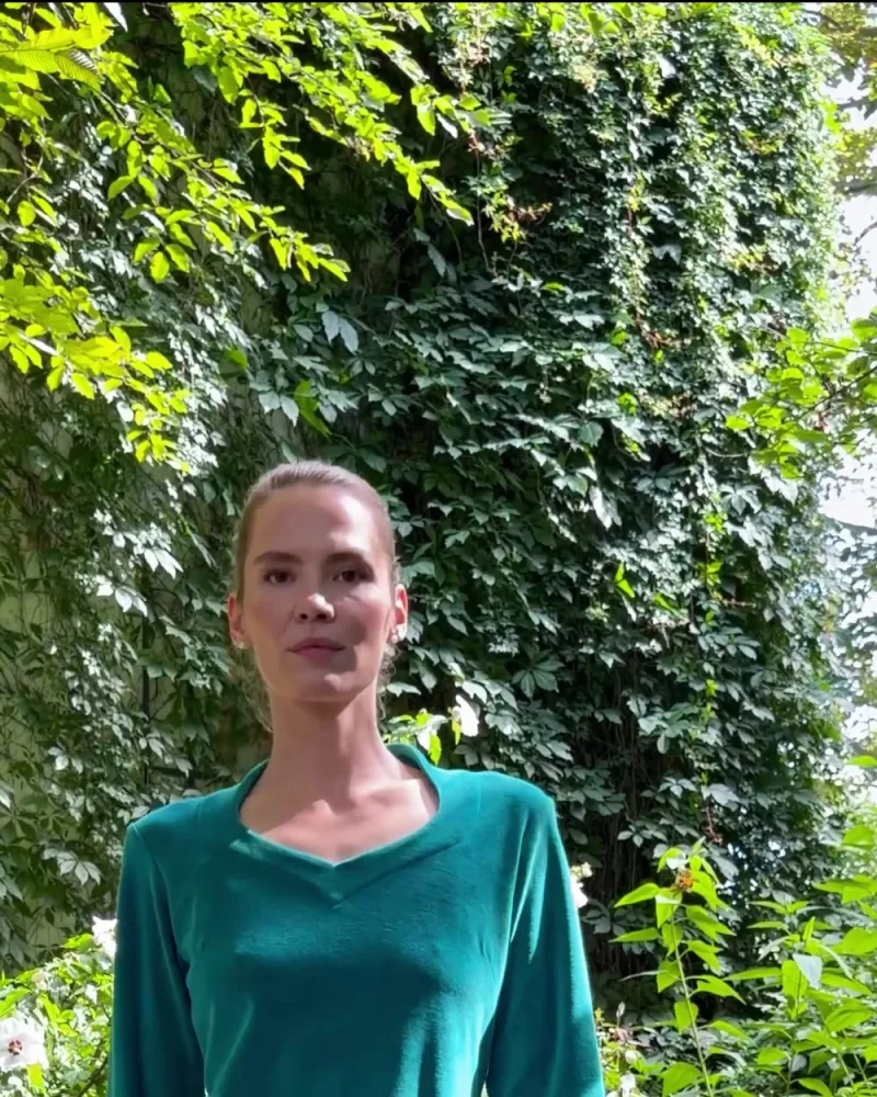 Elisabeth geht im Kleid Kahina und schwarzer Hose durch den Garten