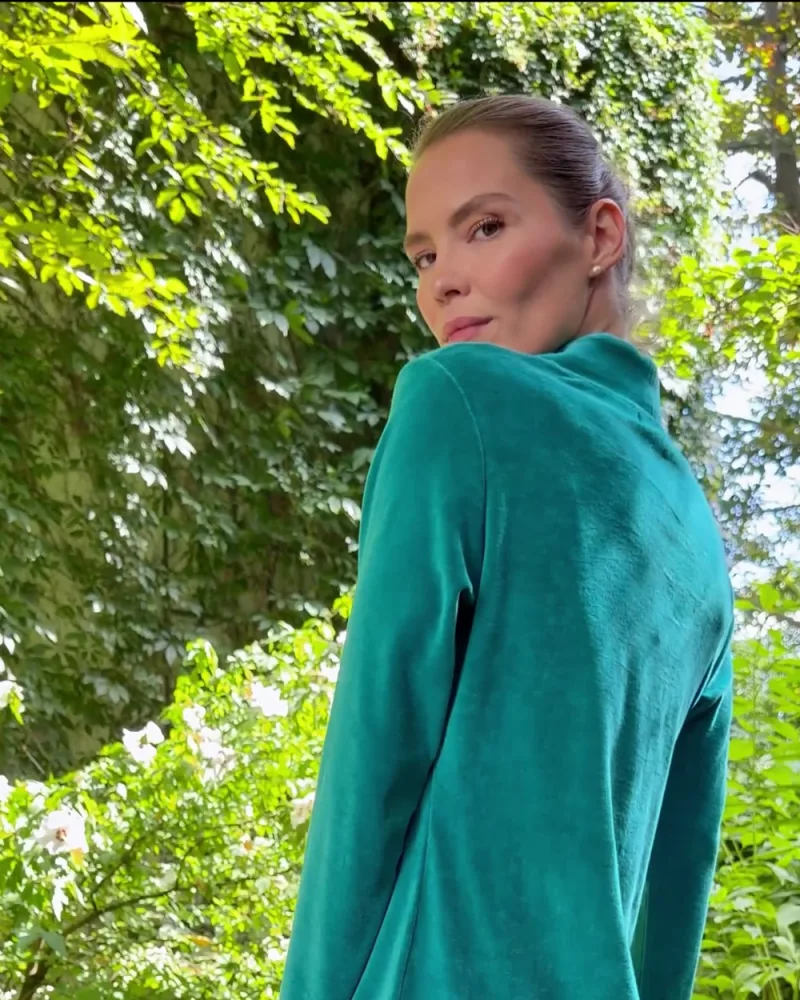 Elisabeth von hinten im petrolfarbenen Kleid Kahina, sie blickt über die Schulter