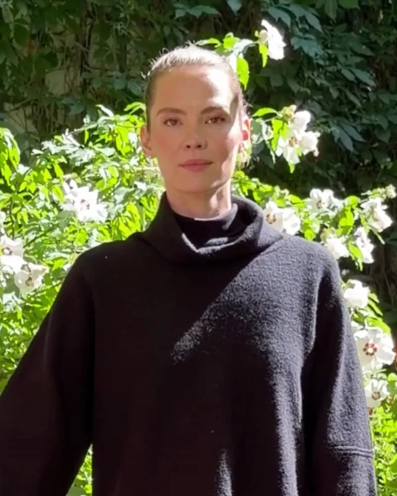 Hamid hält den Ärmel des schwarzen Pullovers Mahsa, den Elisabeth trägt